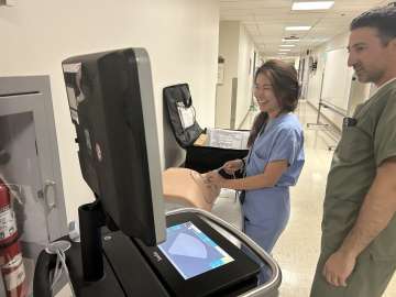 Two hospitalists operating paracentesis trainer mannequin