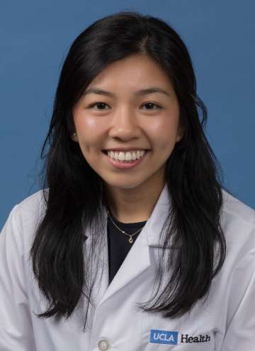 Head shot of Elaine Ramirez in white lab coat, smiling at camera