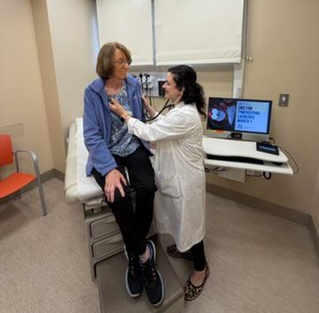 Doctor listening to patients heart in office