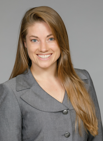 Head shot of Neva Lundy in business attire, smiling at camera