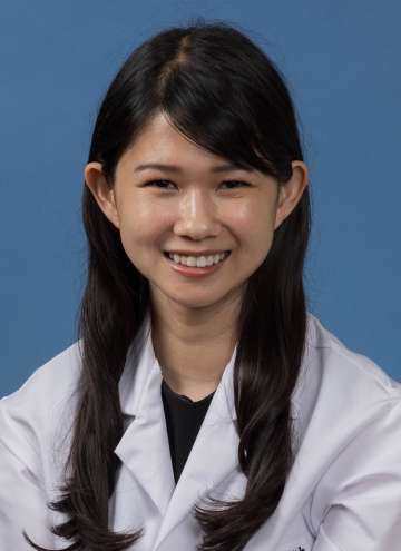 Head shot of Edith Yuan in white lab coat, smiling at camera
