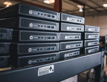 a large amount of black computer servers stacked on top of each other inside of an office