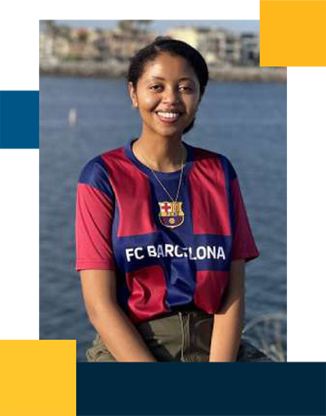 Resident Enat Arega in front of a body of water while wearing a jersey