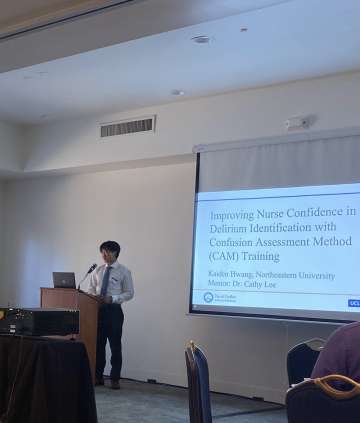 A MSTAR student presenting in a conference hall with an audience