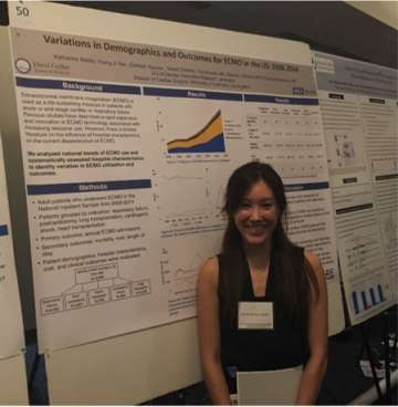 ECMO Research - Woman standing in front of board with research information