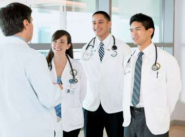 Medical students smiling and looking at a teacher.