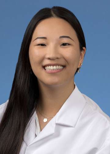 Head shot of Joyce Lee in a white coat, smiling at the camera