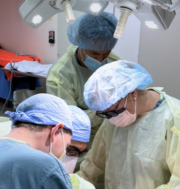 Four surgeons in operating room