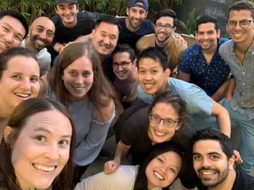 A group of people smiling and posing together outdoors.