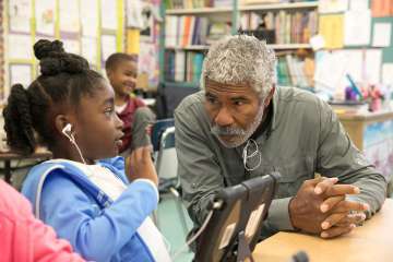 An older man speaking with a young female student