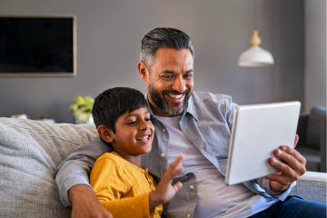Man and young son with tablet at home