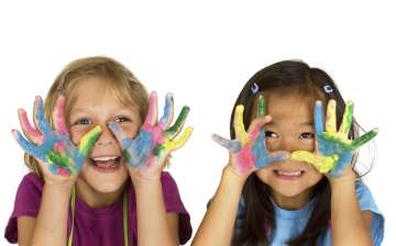 girls smiling with paint on the palms of their hands
