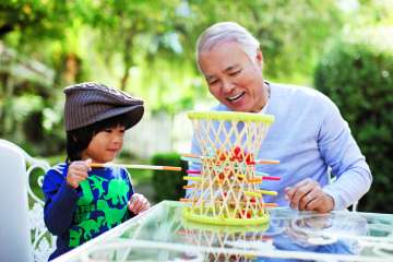Man and boy playing marble game on table