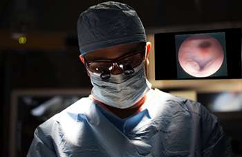 Doctor performing surgery wearing magnifying goggles