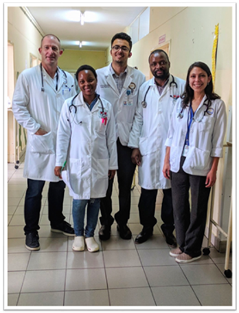 Dr. Buck and four other physicians posing in a hospital hallway in Mozambique