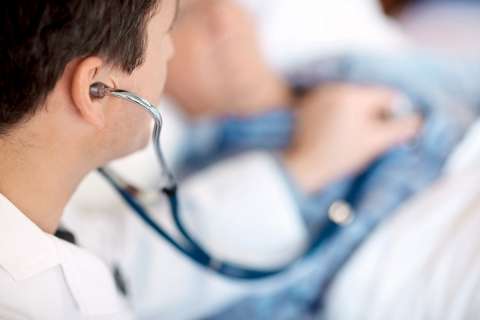 Doctor checking patient's heartbeat