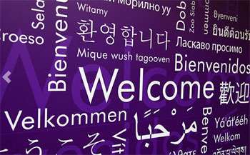 Welcome written in text on a wall in different languages