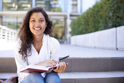 medical student reading a book on the stair steps