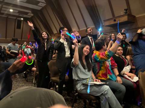 a large audience of Internal Medicine Residents enjoying a concert from the co-resident band