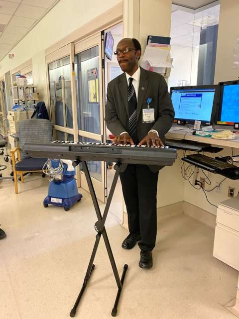 A volunteer musician playing outside the room