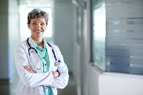 Female doctor standing in hallway smiling