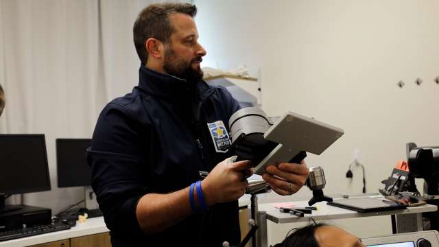 Person holding a handheld device and tablet in a lab setting