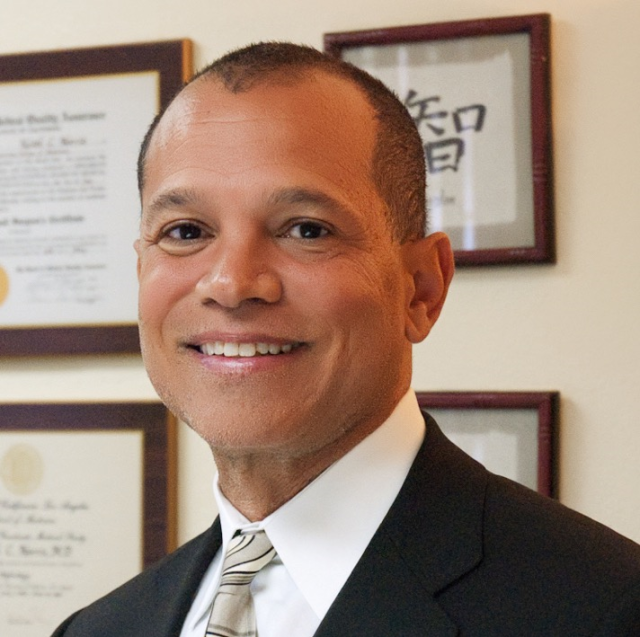 Dr. Keith C. Norris, UCLA Health physician, smiling in a professional headshot wearing a dark suit and patterned tie.