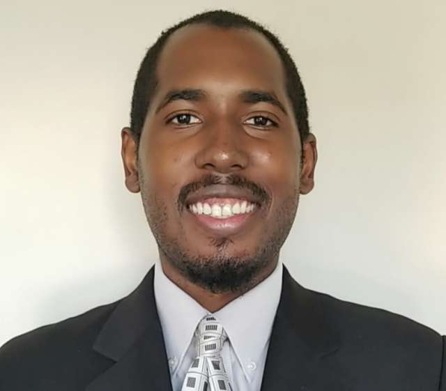 Maurice Turner in a suit and tie against a neutral background.
