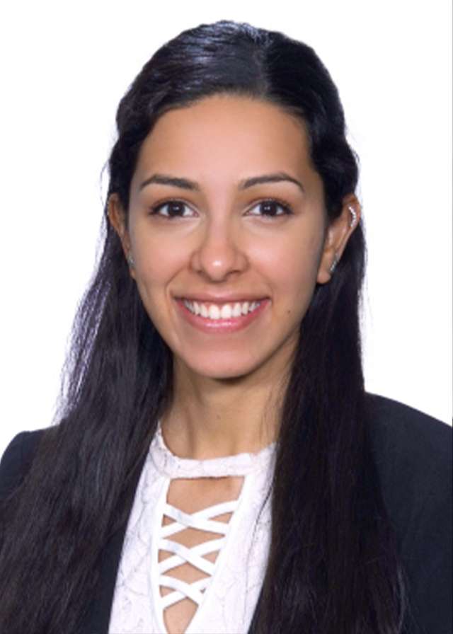 Professional headshot: smiling woman with long dark hair, blazer and white blouse