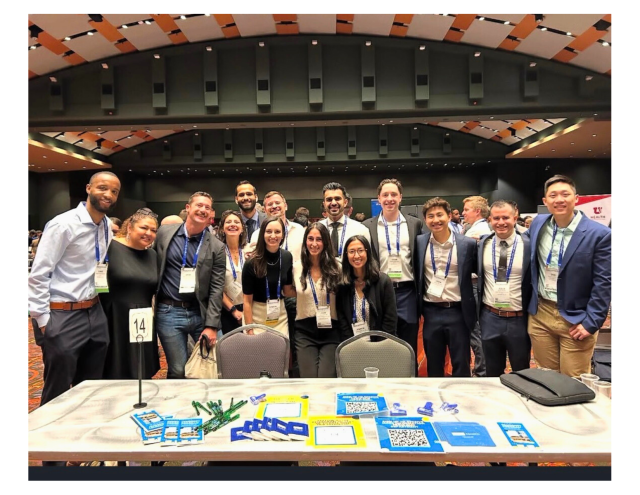 Group photo of a diverse team in a conference setting, smiling together.