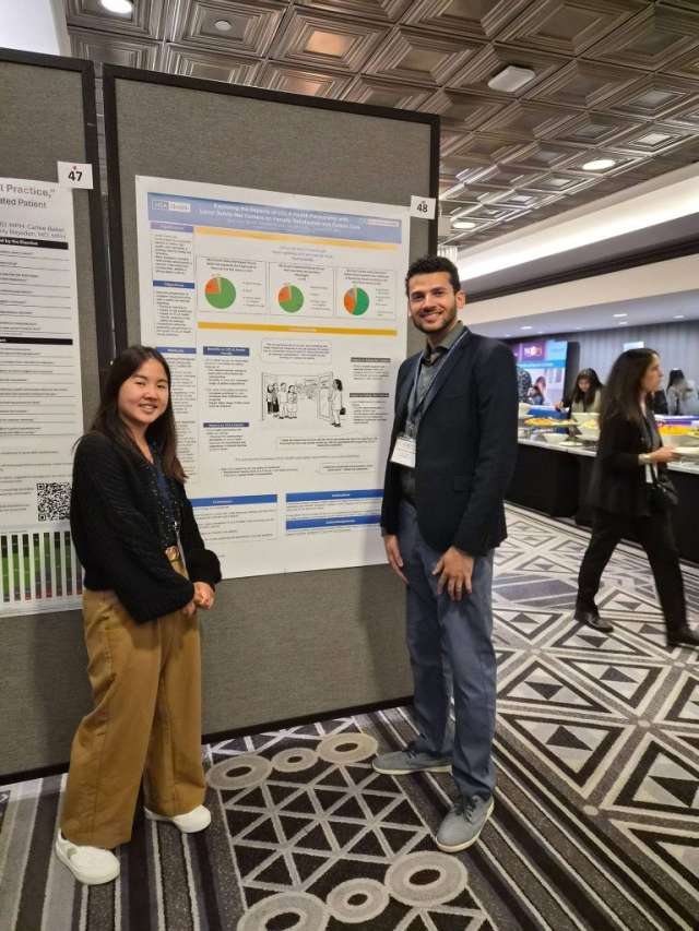 Two people standing beside a research poster in a conference hall
