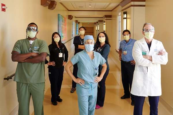 UCLA Health faculty and staff stand in a hospital hallway.