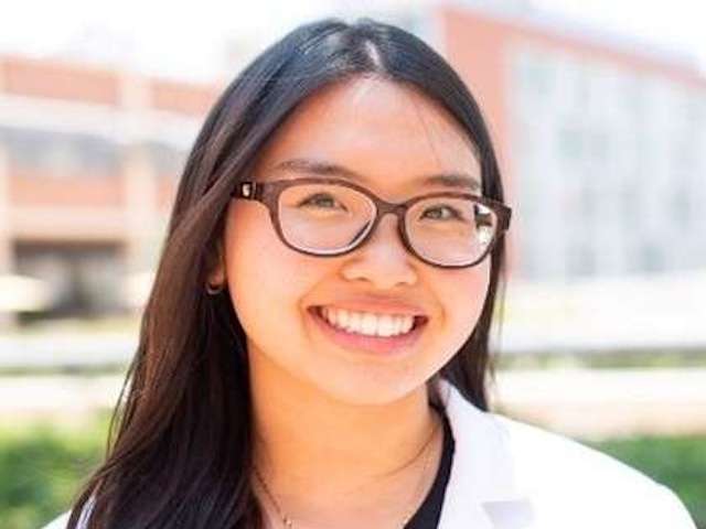 Female nurse wearing glasses and smiling for the camera