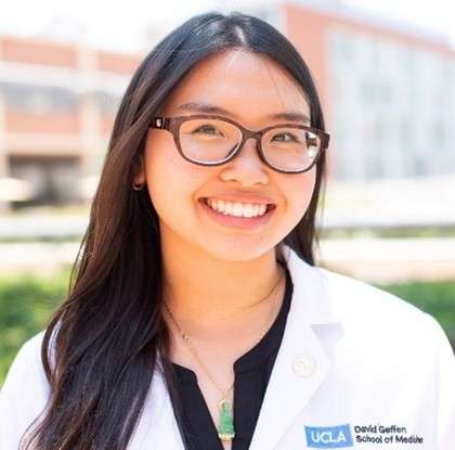 Female nurse wearing glasses and smiling for the camera