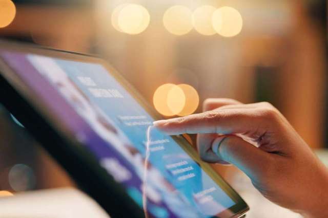 Finger scrolling through content on a tablet screen with a blurred background