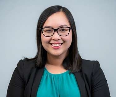  A headshot of Jessica Phan, a smiling woman with dark hair and glasses, wearing a black blazer over a teal top.