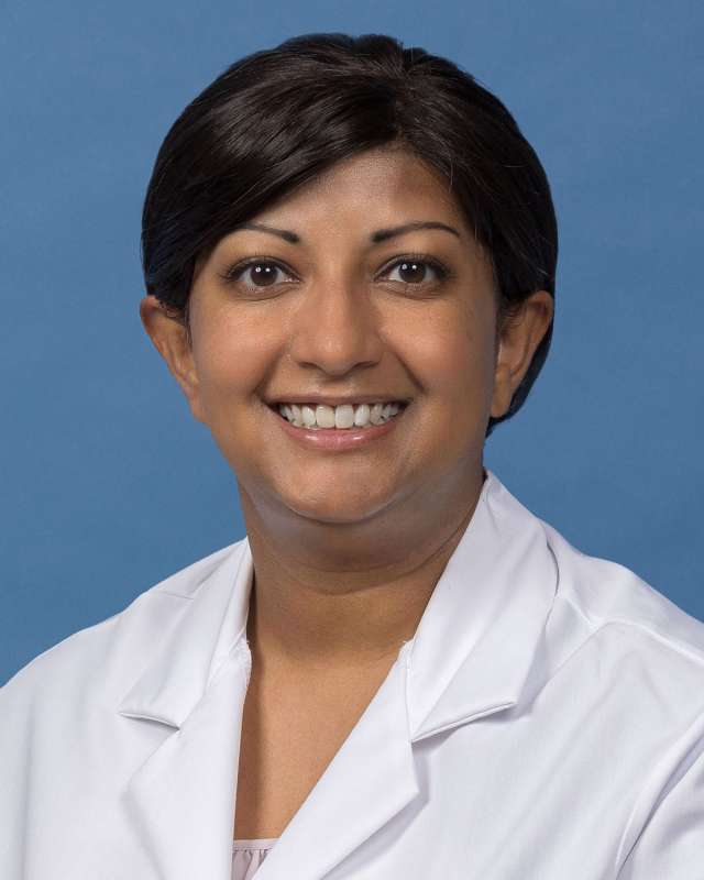Suki Chandrasekaran, PhD in a white lab coat