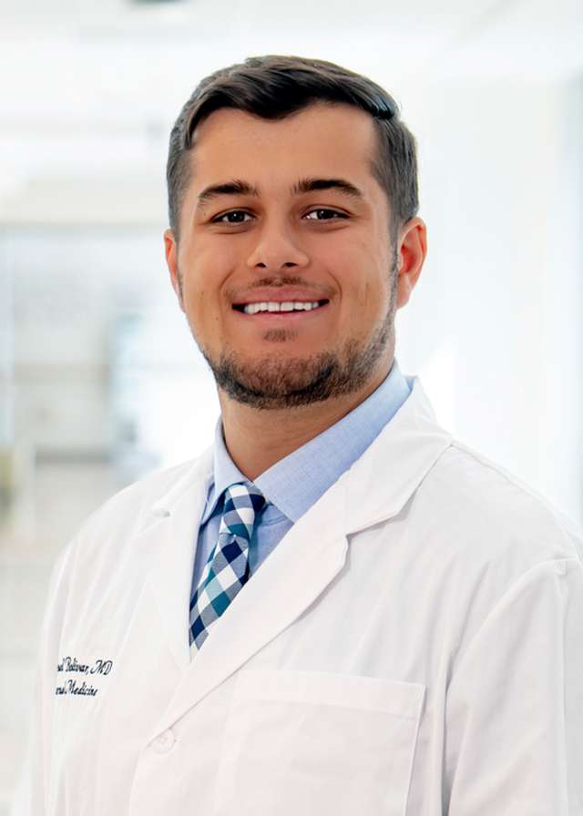 Headshot of Samuel Bolivar, MD in a white Lab Coat