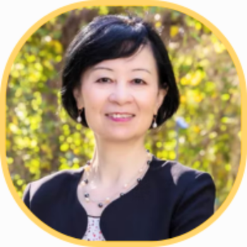 Dr. Lin Zhan headshot in black blazer and leafy background