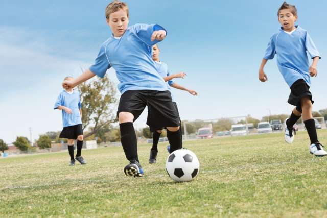 Four kids playing soccer