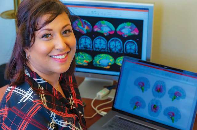 Dr. Arpana Gupta seated by monitors