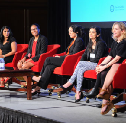 A panel of five women sitting down on stage during a Q&A session.
