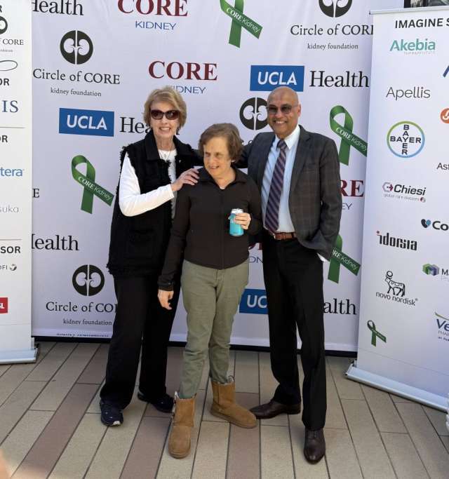Three people pose in front of event backdrop with CORE and UCLA Health logos