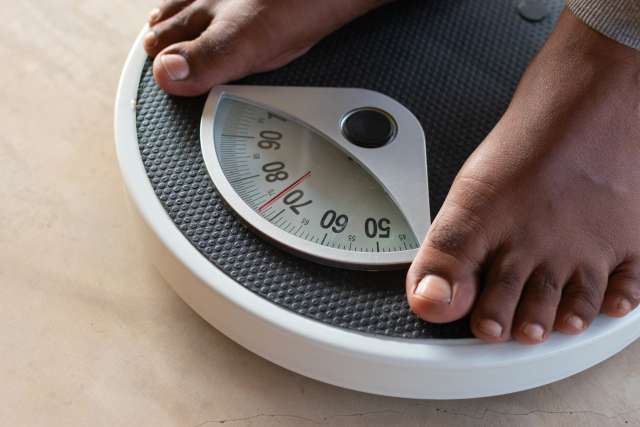 male standing on a weight scale