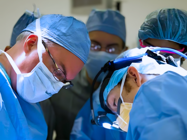 a group of doctors in the operating room performing general surgery