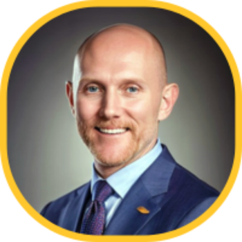 Max Topaz in navy suit and tie with central facial blur and circular yellow frame