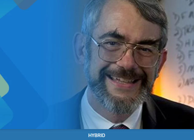 Dr. Kastner headshot, wearing glasses, a white button up shirt with a tie, and a black suit jacket.