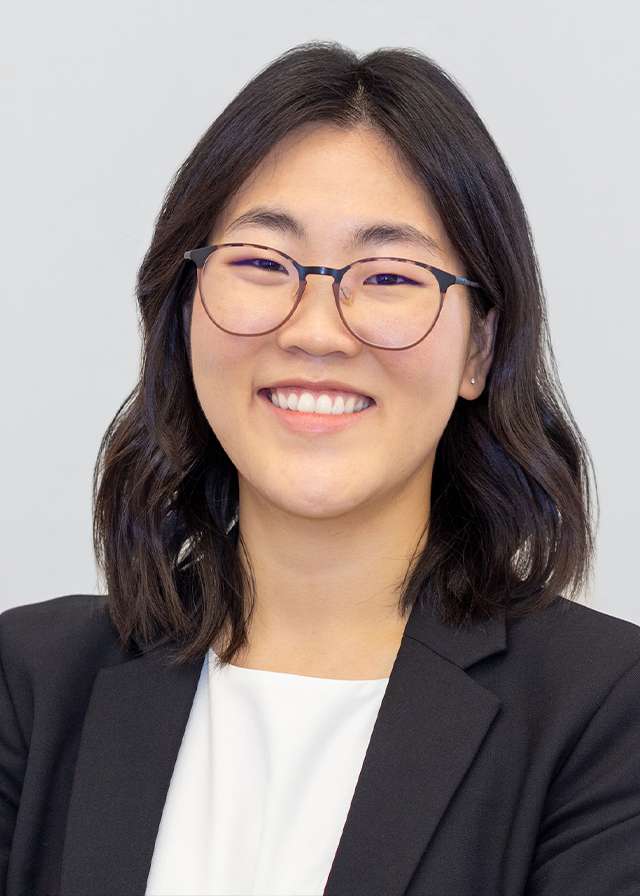 Smiling woman wearing glasses and black blazer in professional headshot
