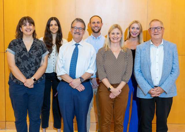 The Max Gray CHAMP Clinic team smiling and looking at camera in professional setting 