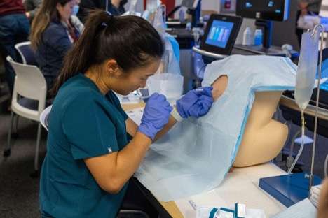 a hospitalists practicing needle injections on a prosthetic